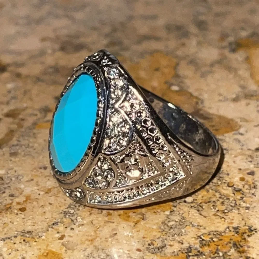 Costume jewelry silver tone ring with turquoise color acrylic center stone.